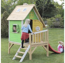 Drevený hrací domček so šmýkačkou v záhrade s hrajúcimi sa deťmi.