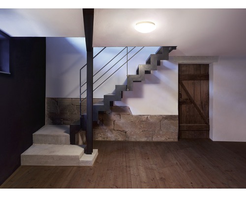 Interiér s betónovým schodiskom, kamennou stenou, drevenou podlahou a stropným svietidlom