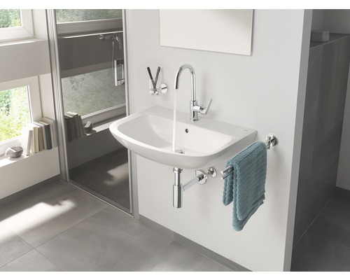 Moderná kúpeľňa s umývadlom, batériou, držiakom na uteráky a sprchou.