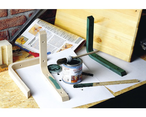 Dielenská scéna s drevenými kusmi, plechovkou farby, štetcom a farbou