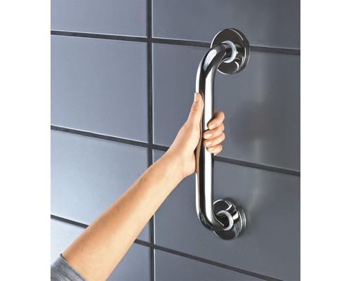 Ruka drží madlo z nehrdzavejúcej ocele na stene