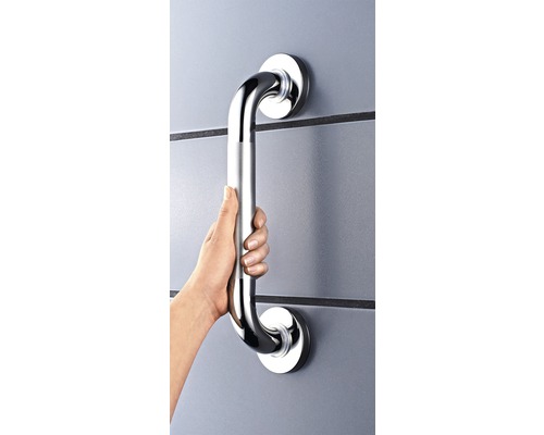 Ruka drží kovové madlo na stene.