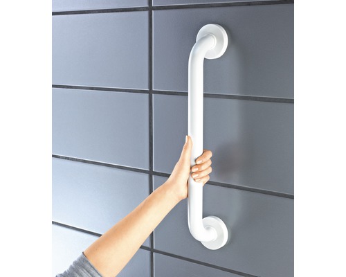 Osoba drží biele držadlo pripevnené k obloženej stene.