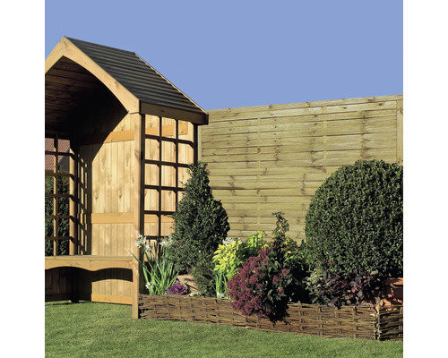 Záhradná krajina s dreveným plotom, vŕbovým záhonom a drevenou chatkou