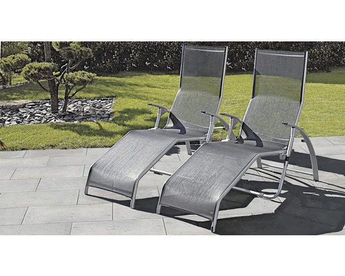 Dve sivé záhradné ležadlá z hliníka a textilu na terase.