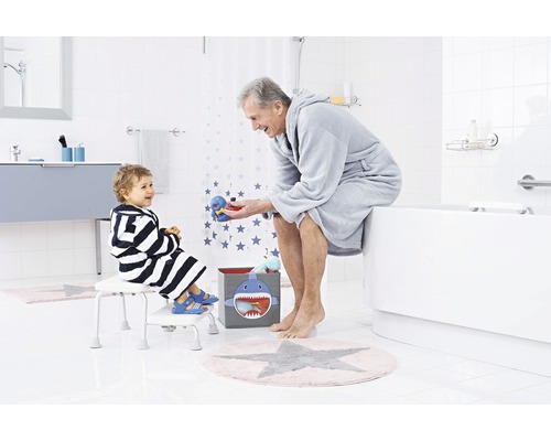 Kúpeľňová scéna s dieťaťom na stoličke a dospelým na vani