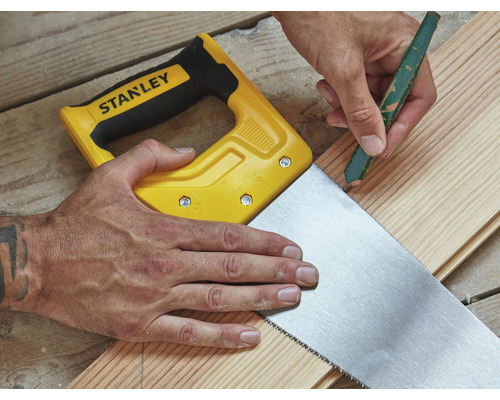 Remeselník označuje drevenú dosku ceruzkou a pílou