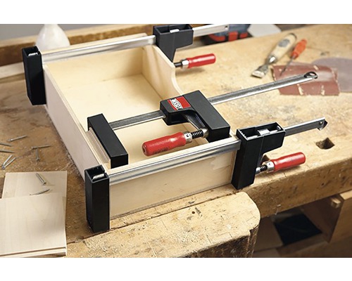 Drevená debna upevnená svorkami na pracovnej lavici