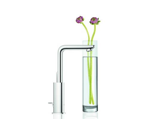 Chrómová umývadlová batéria vedľa pohára s kvetmi