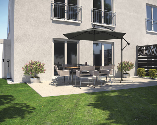 Terasa so záhradným stolom, stoličkami a slnečníkom vedľa obytného domu.