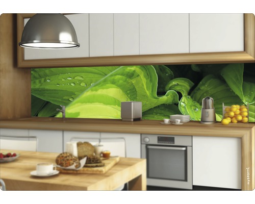 Kuchynská scéna s kuchynskou doskou s motívom rastlín, kuchynským náčiním a potravinami na pracovnej doske.