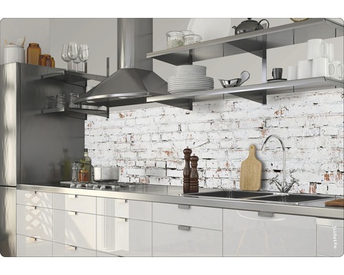 Moderná kuchyňa s nerezovými spotrebičmi a pracovnou doskou pred stenou so vzorom tehál