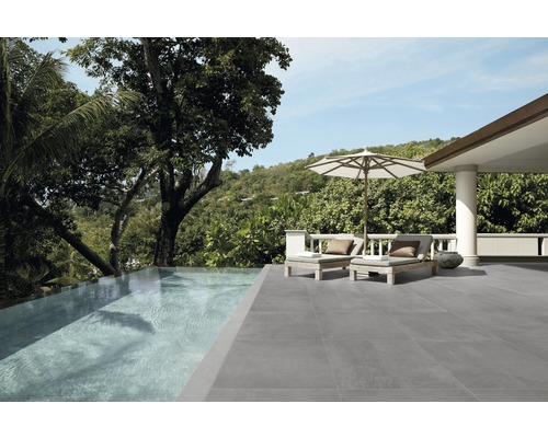 Exteriér so sivou dlažbou, bazénom a ležadlami