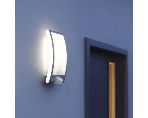 Svietiace vonkajšie nástenné svietidlo s detektorom pohybu vedľa dverí