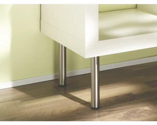 Detail bielej skrine s kovovými nohami na drevenej podlahe