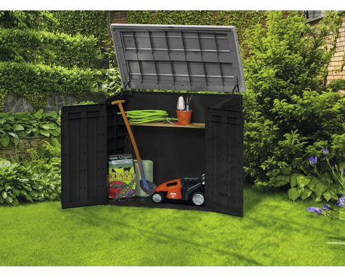 Otvorená záhradná skrinka so záhradným náradím v trávniku