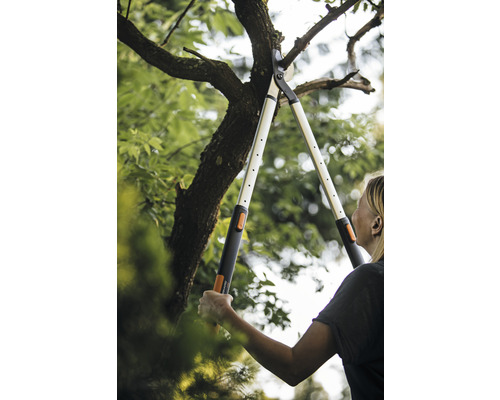 Žena strihá konáre stromov pomocou pákových nožníc na konáre