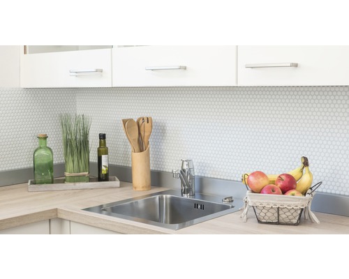 Kuchynský drez s batériou, pracovná doska a dekorácia vo svetlej kuchyni