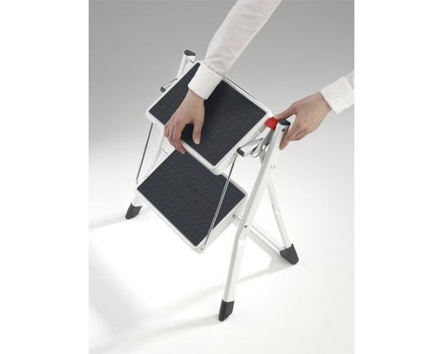 Osoba rozkladá dvojstupňový rebrík pre domácnosť.