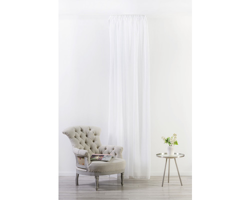 Svetlá izba s kreslom, príručným stolíkom s vázou kvetov a závesom