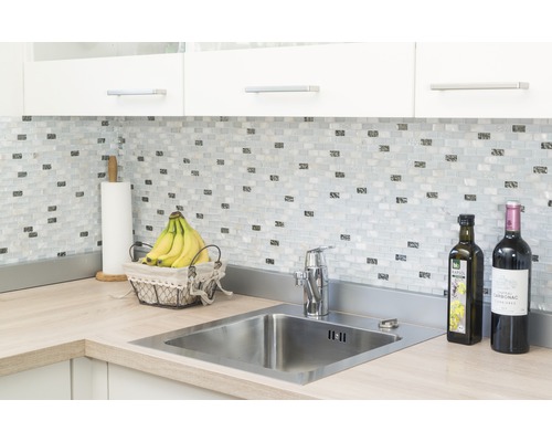 Kuchynská scéna s drezom, vodovodnou batériou, mozaikovými dlaždicami a pracovnou doskou