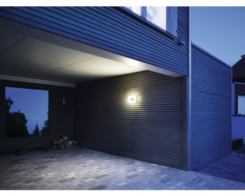 Exteriér moderne navrhnutého domu s vonkajším osvetlením a dláždenou príjazdovou cestou