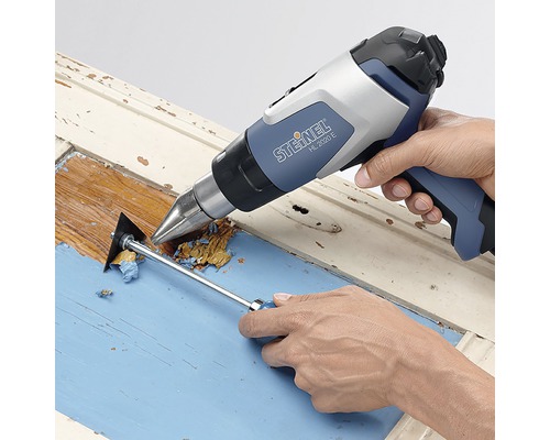 Teplovzdušná pištoľ odstraňuje farbu z dreveného rámu