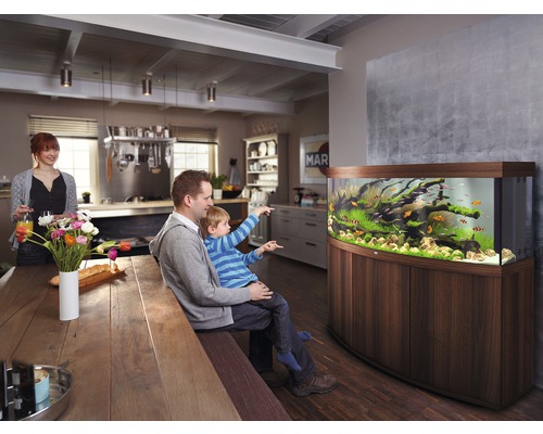 Obývacia izba s akváriom, muž a dieťa sledujú ryby, žena v pozadí