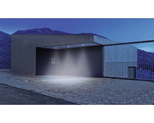 Osvetlený príjazd s modernou architektúrou a horskou krajinou v pozadí