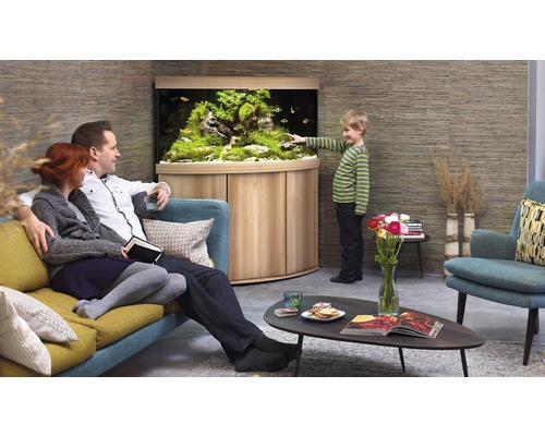 Rodina sa pozerá na akvárium v obývacej izbe s drevenou skriňou