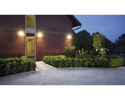 Vonkajšia fotografia domu s murovanou stenou a záhradným osvetlením