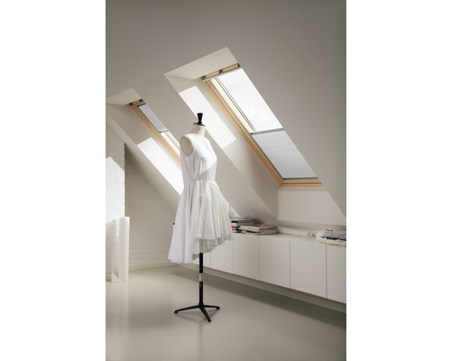 Podkrovná izba s dvoma strešnými oknami, bielou vstavanou skriňou a krajčírskou pannou s bielymi šatami