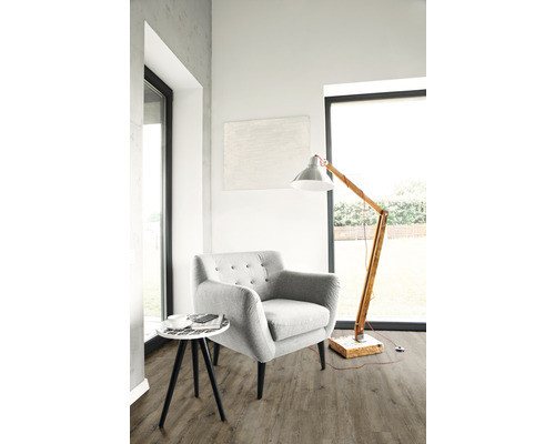 Svetlá obývacia izba s kreslom, stojacou lampou a odkladacím stolíkom na podlahe