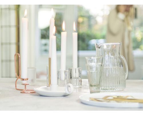 Ozdobný stôl so sviečkami, svietnikmi, pohármi a džbánom