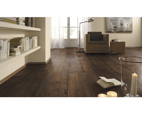 Obývacia izba s laminátovou podlahou s dreveným vzhľadom, regálmi, kreslom a dekoráciou