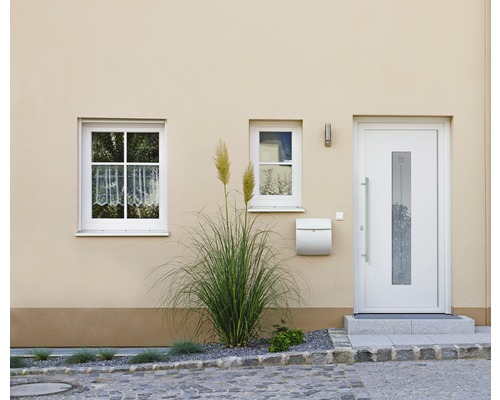 Fasáda obytného domu s vchodovými dverami, oknami a poštovou schránkou