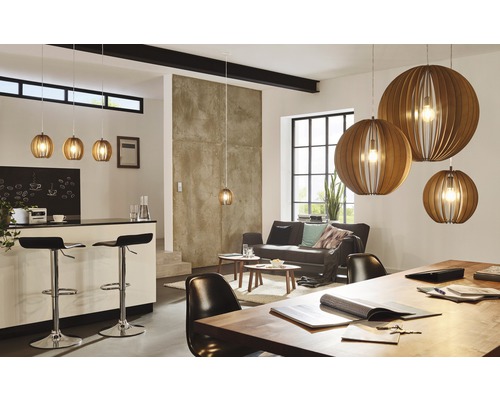 Svetlá obývacia izba s kuchynským barom, pohovkou a niekoľkými drevenými závesnými svietidlami