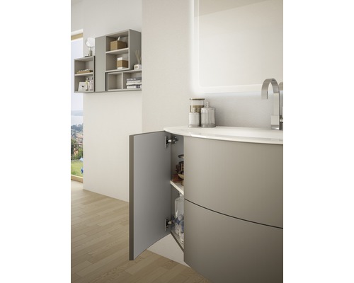 Kúpeľňa s umývadlovou skrinkou, otvorenou skrinkou a osvetleným zrkadlom