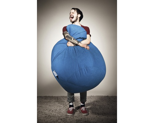 Muž objíma modrý sedací vak v interiéri