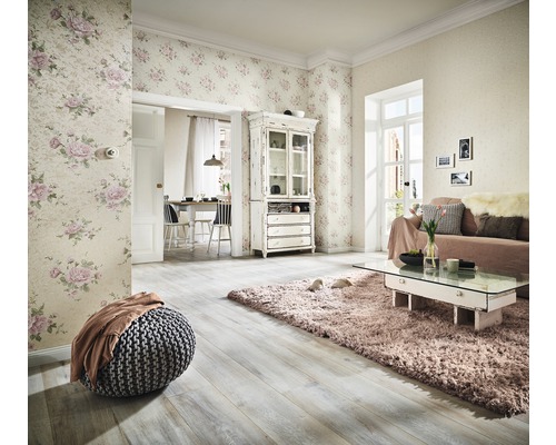 Obývacia izba s kvetinovou tapetou, pohovkou, kobercom a drevenou podlahou pre svetlé prostredie.