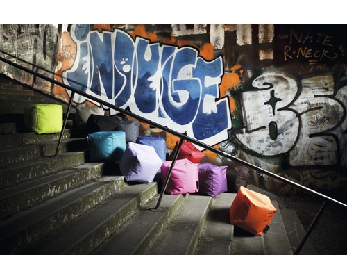 Niekoľko sedacích kociek na schodoch pred stenou s graffiti