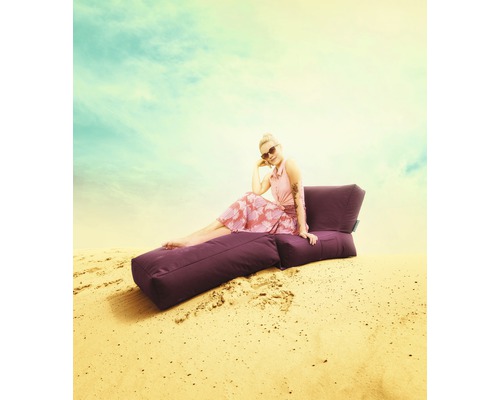 Žena sedí vonku na fialovom sedacom vaku