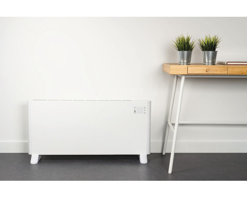 Elektrický radiátor vedľa písacieho stola s dekoráciou