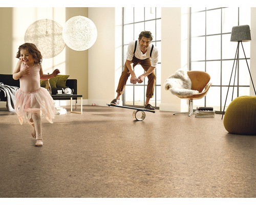 Obývacia izba s korkovou podlahou, hrajúcim sa dievčaťom a mužom na balančnej doske