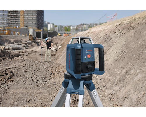 Stavenisková scéna s rotačným laserom Bosch na statíve na vodorovné vyrovnávanie