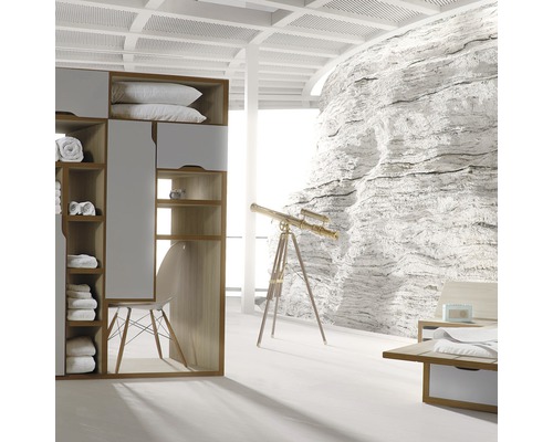 Svetlá spálňa so šatníkovou skriňou, kreslom, teleskopom a dekoráciou kamennej steny