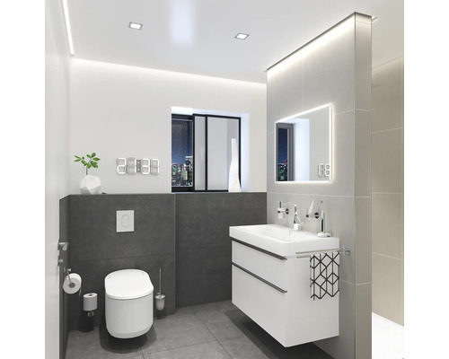 Moderná kúpeľňa s toaletou, skrinkou pod umývadlo, zrkadlom a digitálnymi hodinami