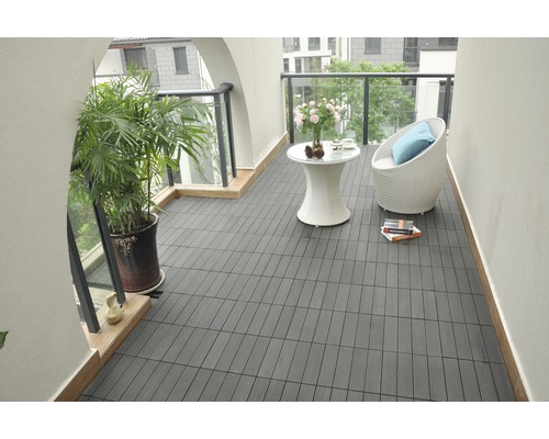 Balkón s tmavými terasovými dlaždicami, posedením a rastlinou