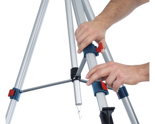 Osoba stavia hliníkový stavebný statív