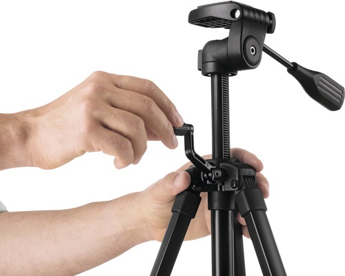 Obsluha čierneho kamerového statívu s hlavou statívu rukami